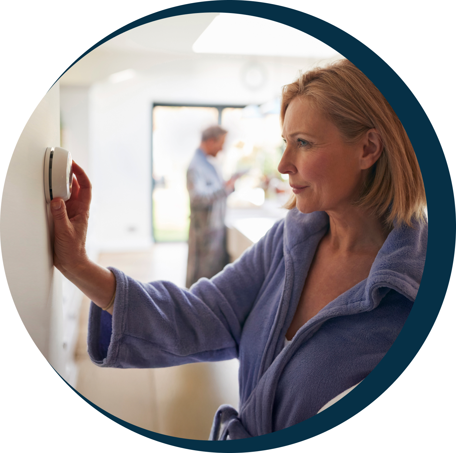 Homeowner adjusting a wall thermostat
